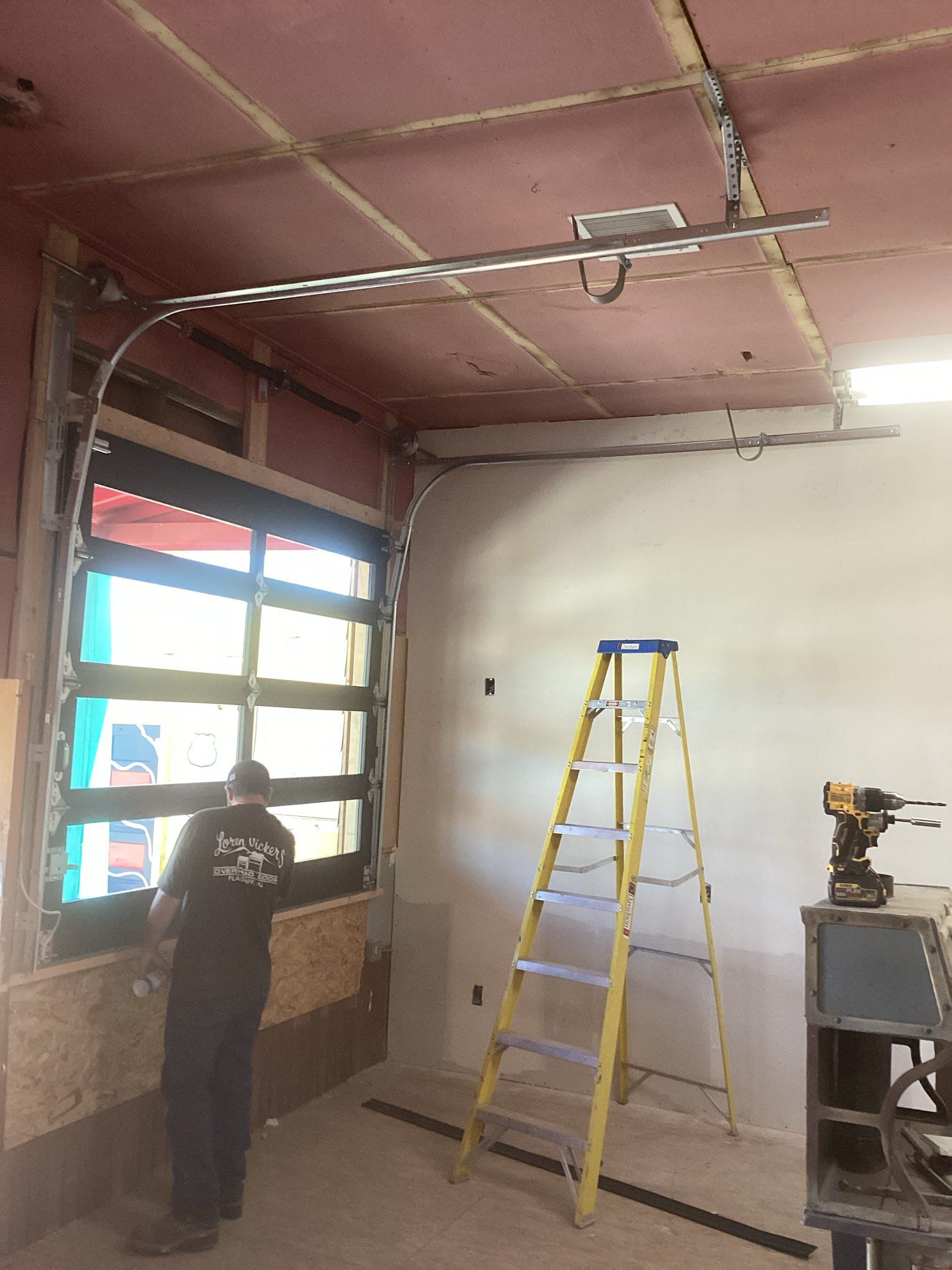 A man is standing in a room next to a ladder.