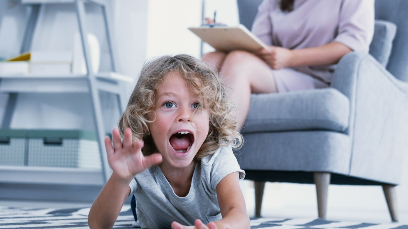 Woman with long brown hair, eyes closed, holding her head, showing distress.
