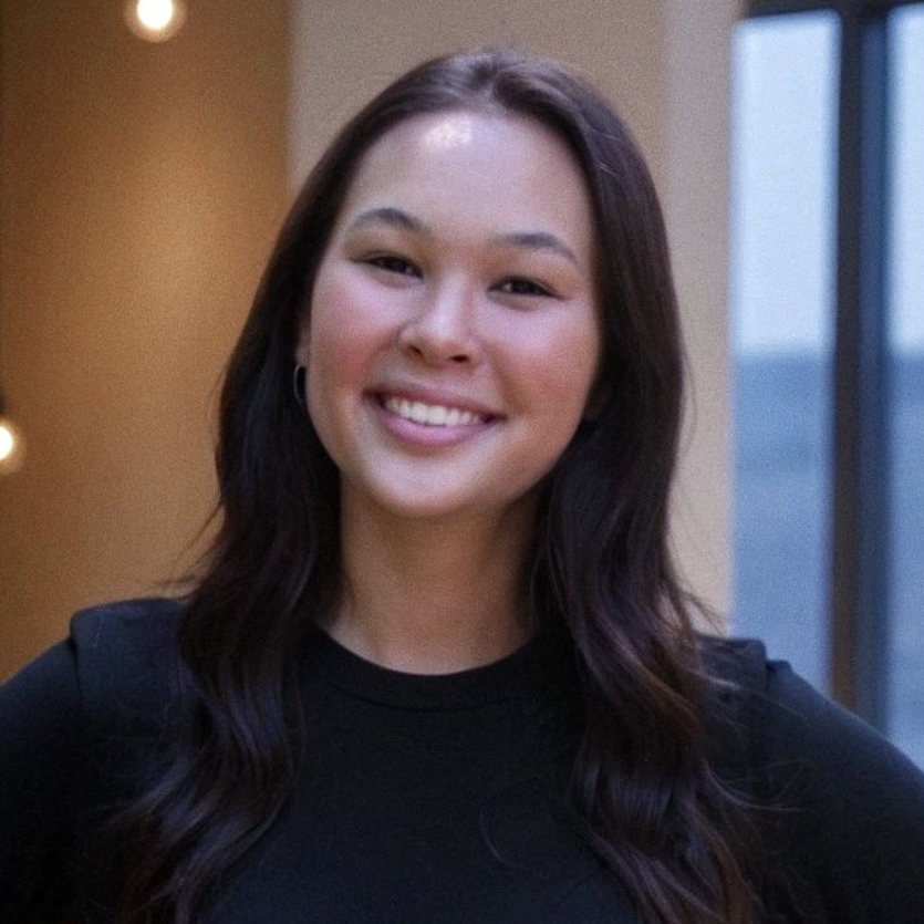 A woman with long blonde hair is smiling for the camera.