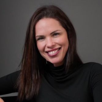 A woman in a black turtleneck is smiling for the camera.