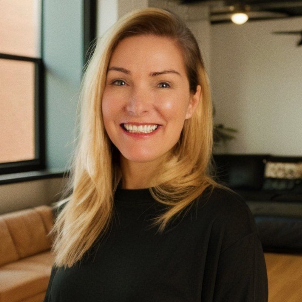 A woman with long blonde hair is smiling for the camera.