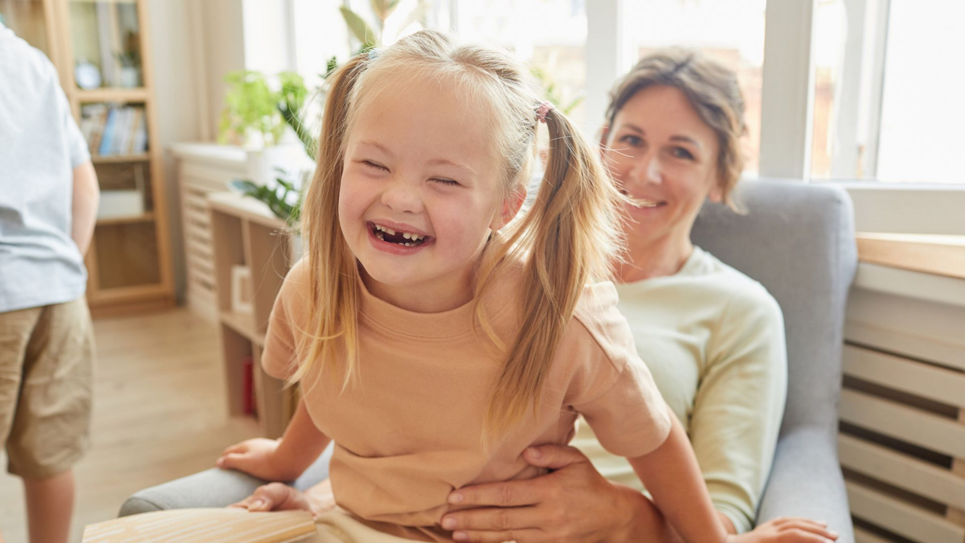 Woman with long brown hair, eyes closed, holding her head, showing distress.