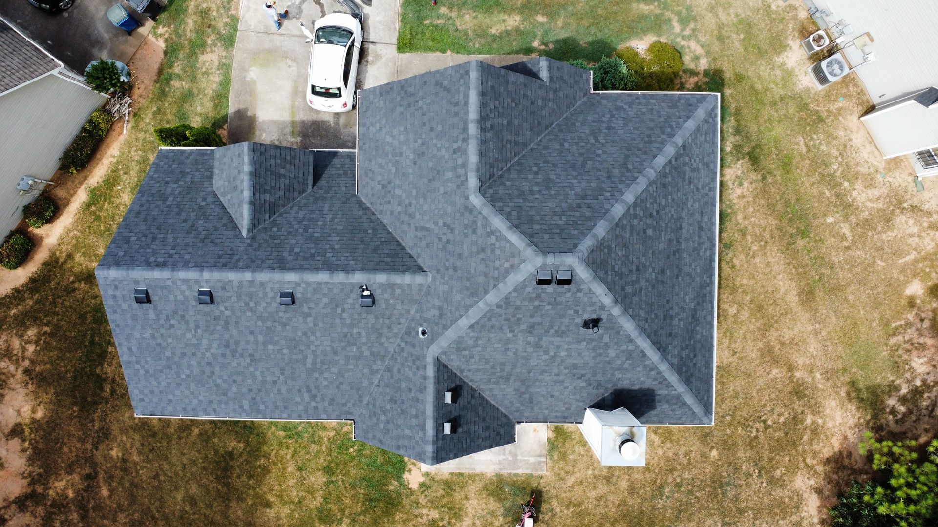 Merck Roofing specialists nailing down asphalt shingles for a residential project in Hall County, Georgia.