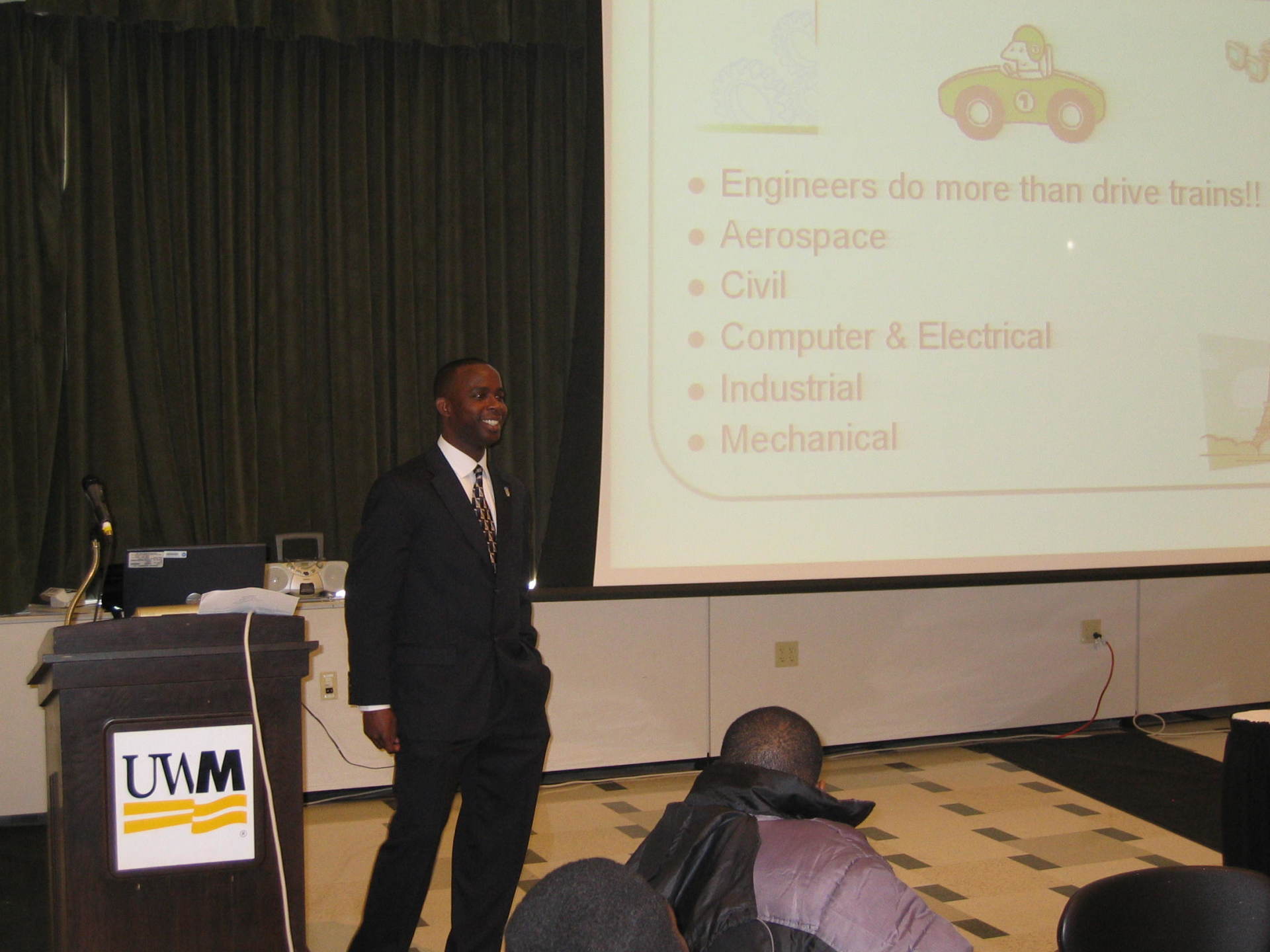 Speaker standing  and speaking with students at previous Positive Images Leadership Teen Summit meeting in Milwaukee