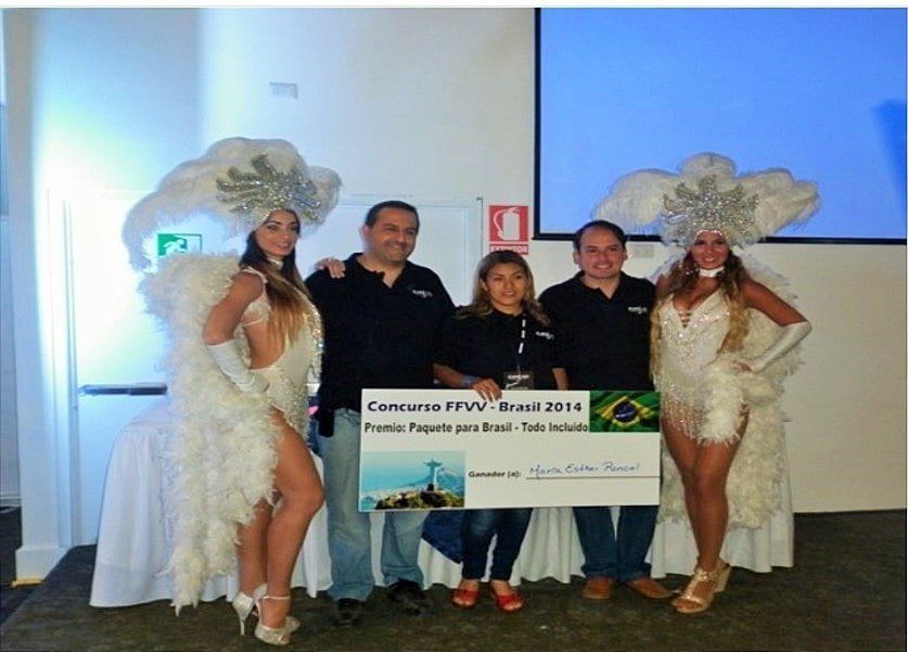 Un grupo de personas posando para una foto con un cheque que dice concurso ffv brasil 2014
