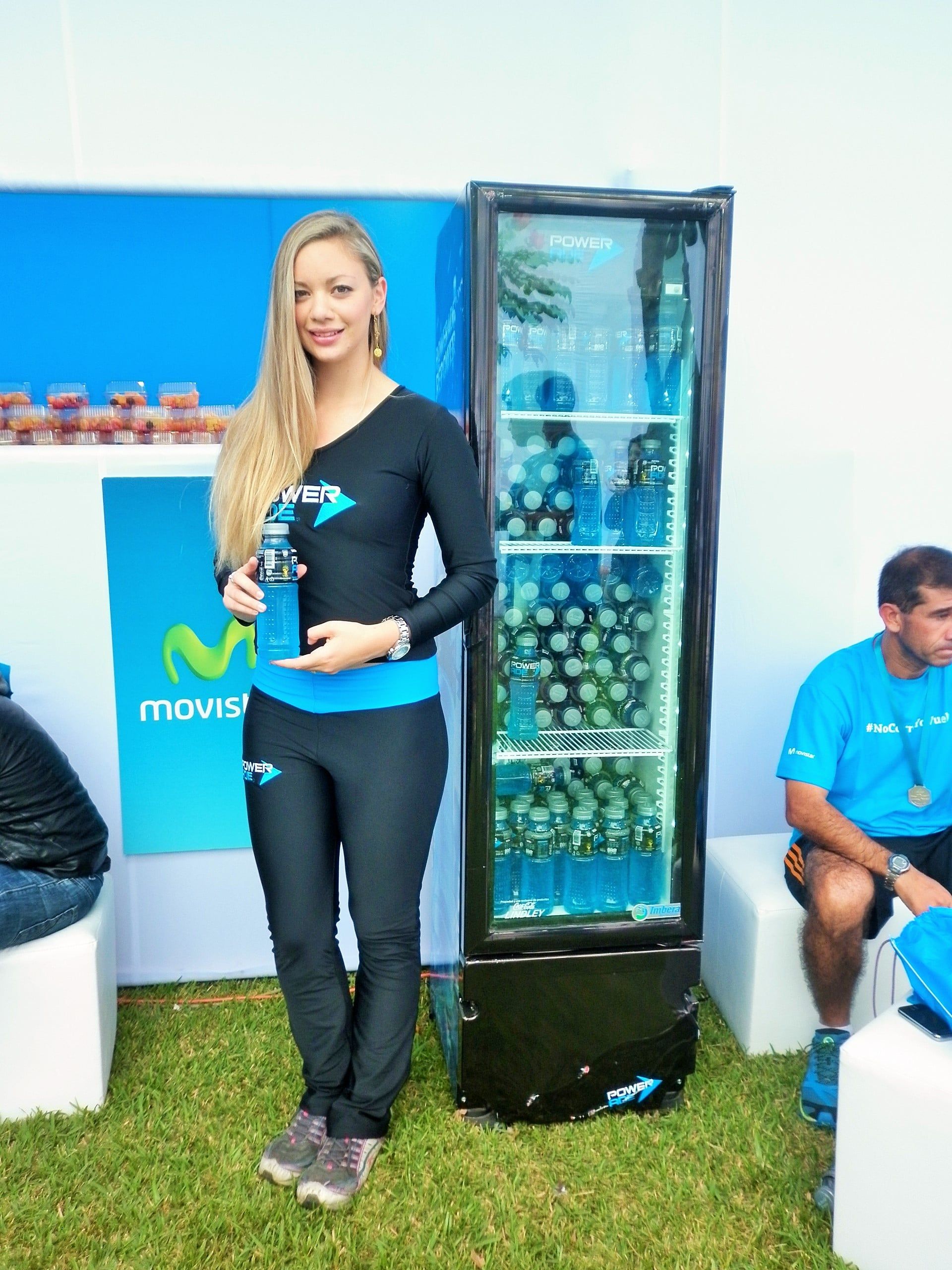 Una mujer está parada frente a un refrigerador que dice Movistar.