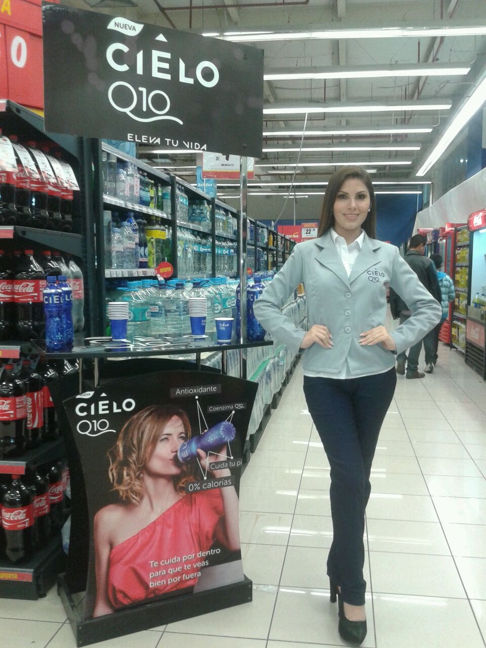 Una mujer está parada frente a un cartel que dice cielo q10