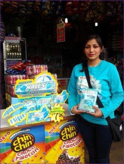 Una mujer con una camisa azul sostiene una bolsa de Chin Chin.