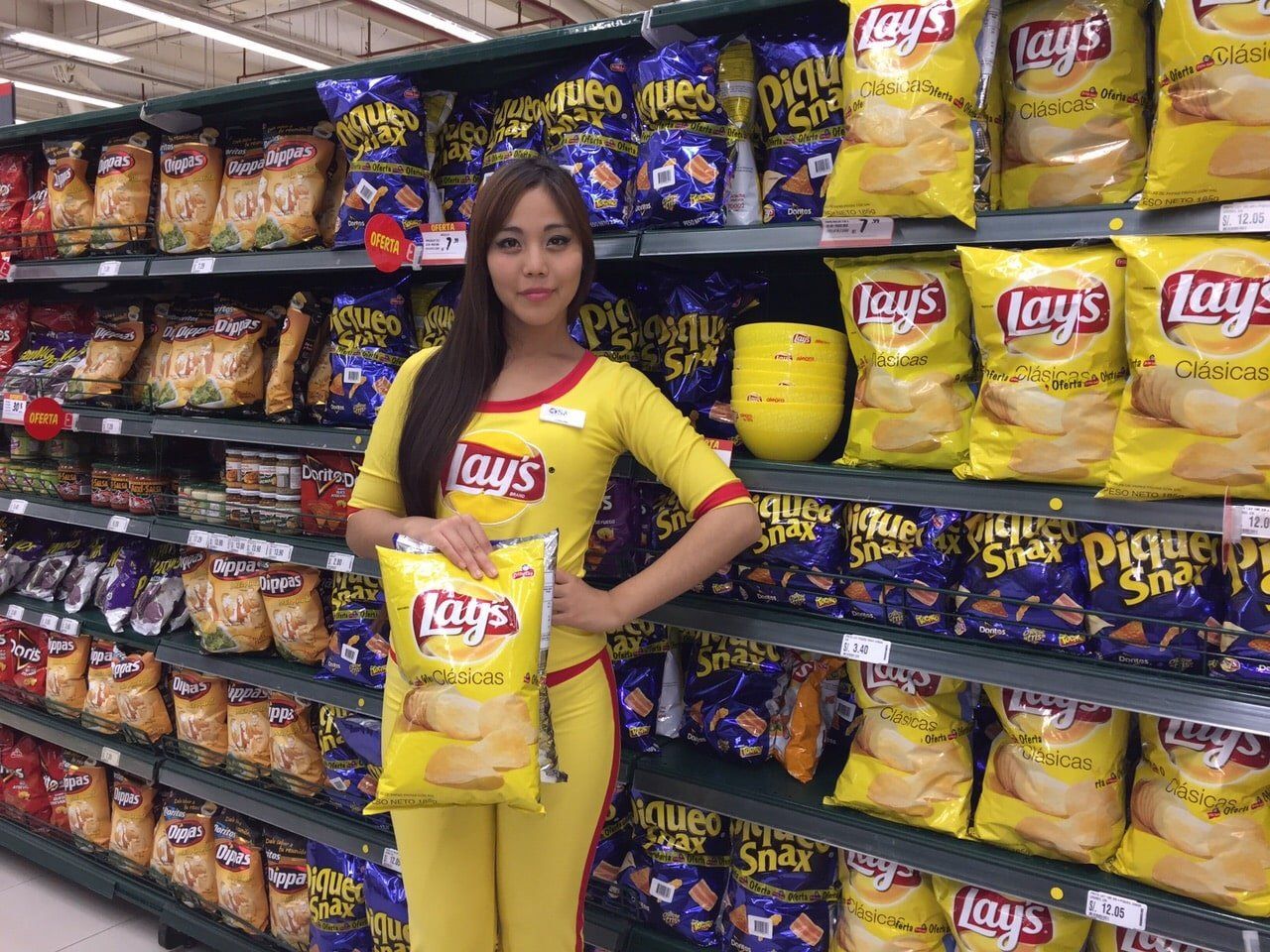 Una mujer sostiene una bolsa de patatas fritas Lays en una tienda.