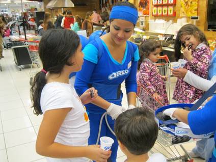 Una mujer con una camiseta azul de Oreo está hablando con un niño.