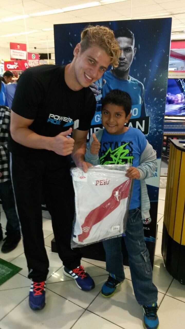 Un niño sostiene una camiseta que dice Perú.