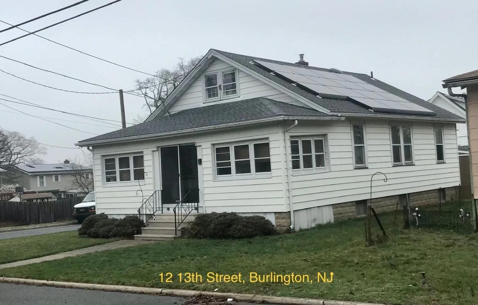 White house with solar panels on the roof, located at 12 13th Street, Burlington, NJ.