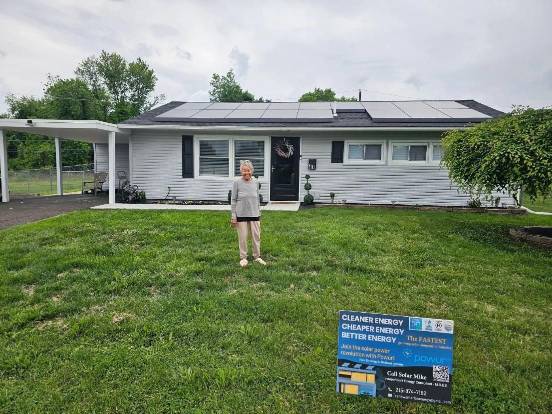 Person standing in front of a house with solar panels. 