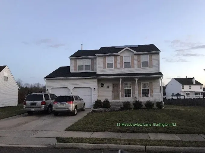 Two-story house with two cars parked in the driveway. Located on Meadowview Lane, Burlington, NJ.