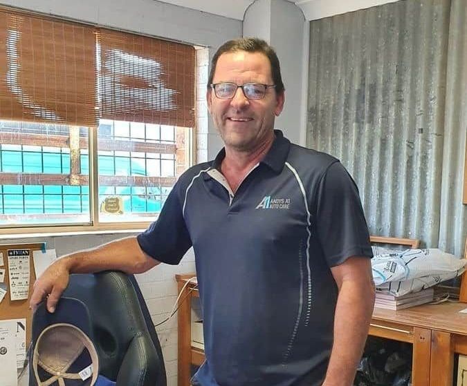 A Man Is Standing Next to A Chair in A Room — Andy's A1 Auto Care in Barrack Heights, NSW