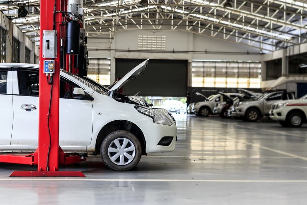 A White Car Is Sitting on A Lift in A Garage — Andy's A1 Auto Care in Barrack Heights, NSW