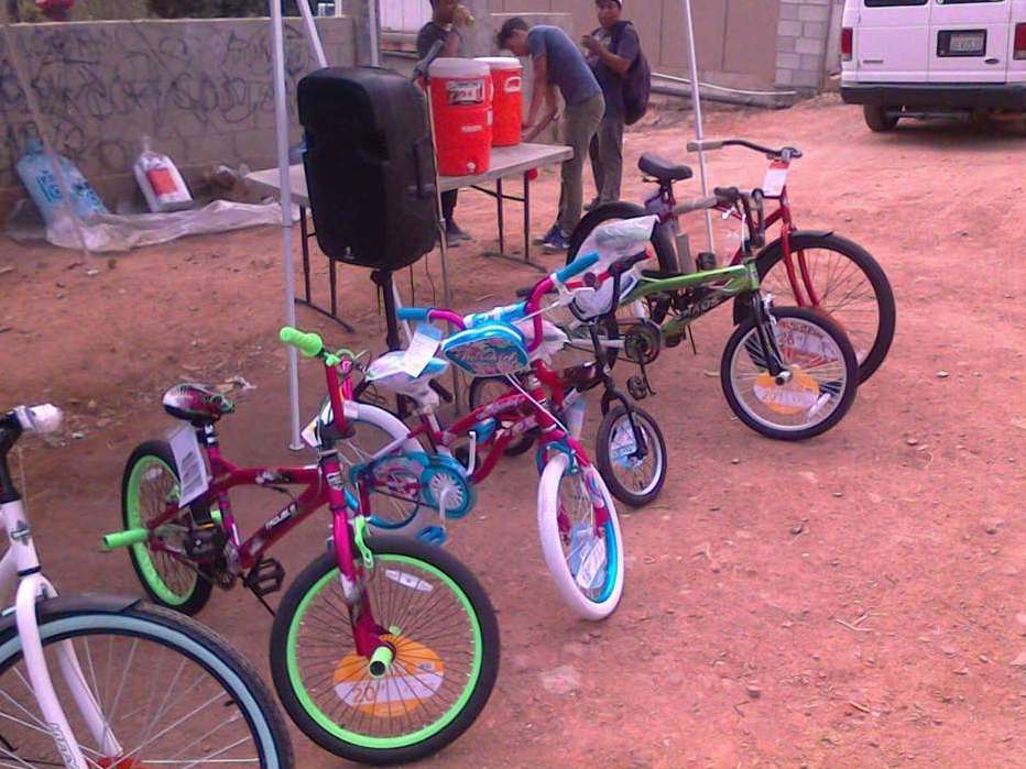A bunch of bikes are parked in a dirt area