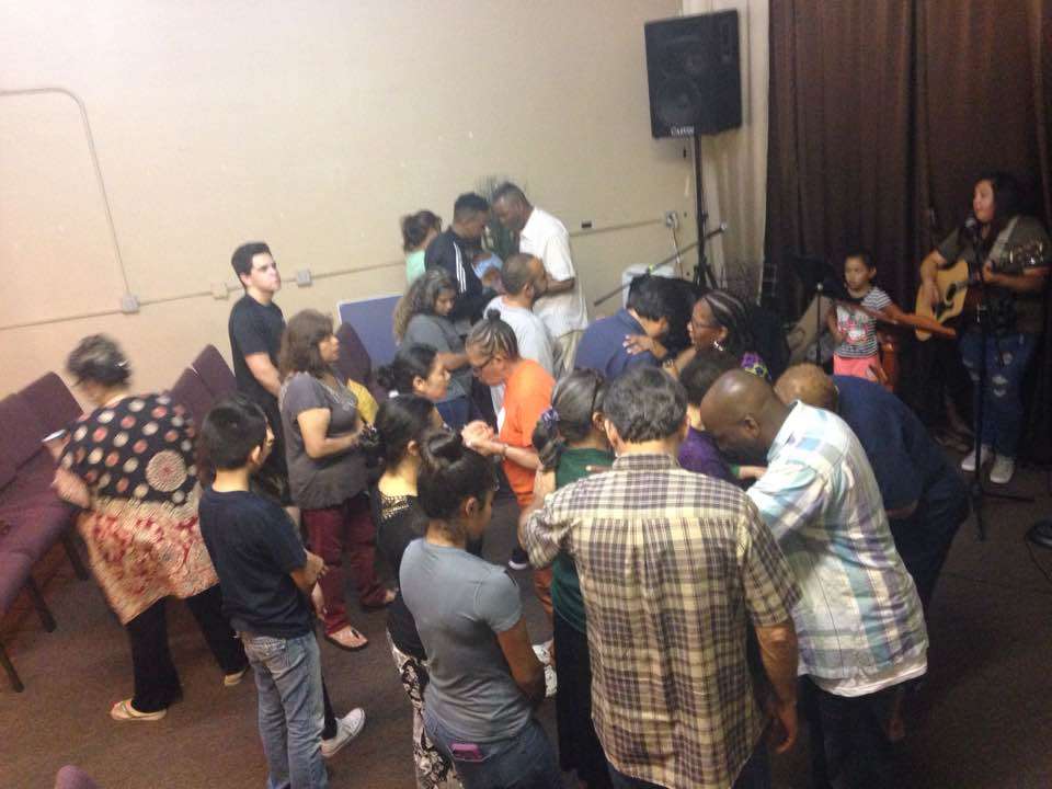 A group of people are standing in a circle in a room.