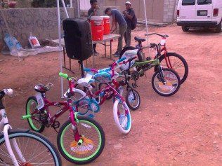 A bunch of bikes are parked in a dirt area