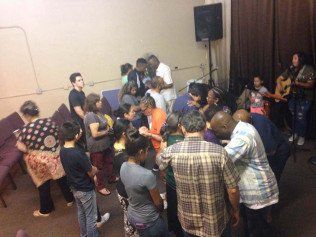 A group of people are standing in a circle in a room.