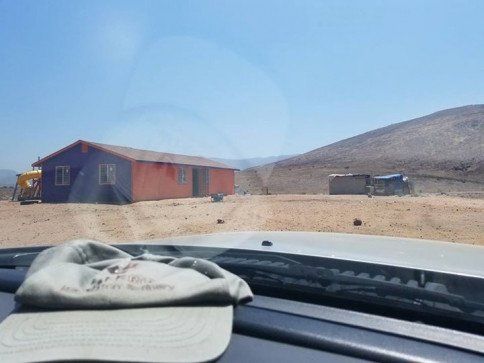 A hat is sitting on the dashboard of a car in the desert