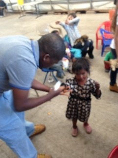 A man in a blue shirt is standing next to a little girl in a black and white dress