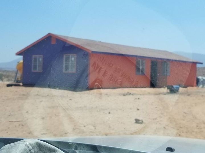 A purple and orange house in the middle of a desert