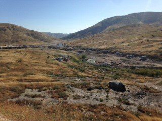 A view of a valley with mountains in the background.