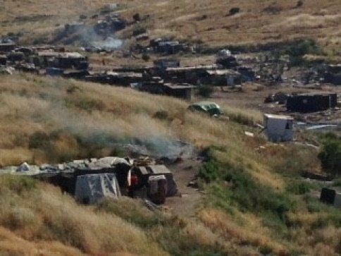 A group of tents are sitting in the middle of a field.