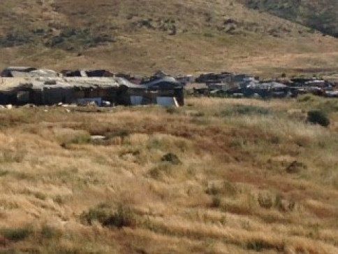 A group of buildings are sitting in the middle of a field.