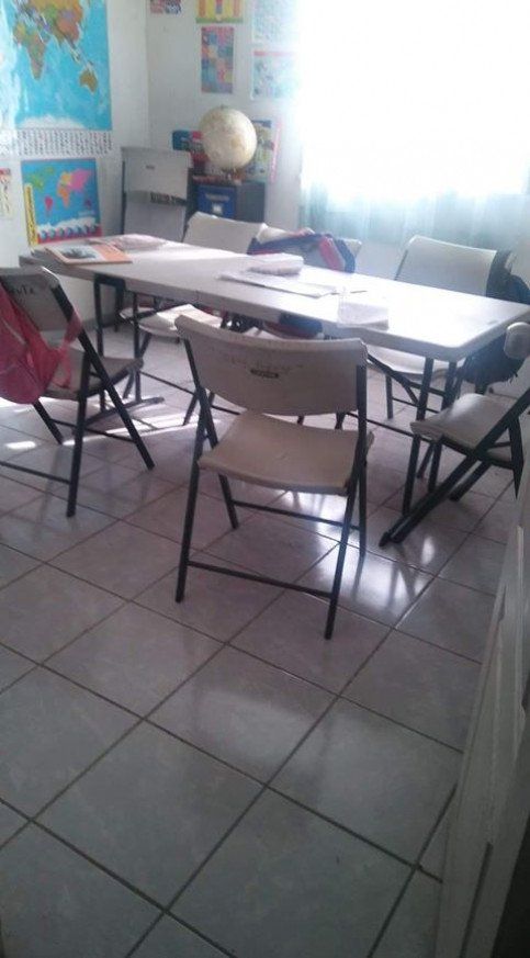 A room with a table and chairs and a map on the wall.