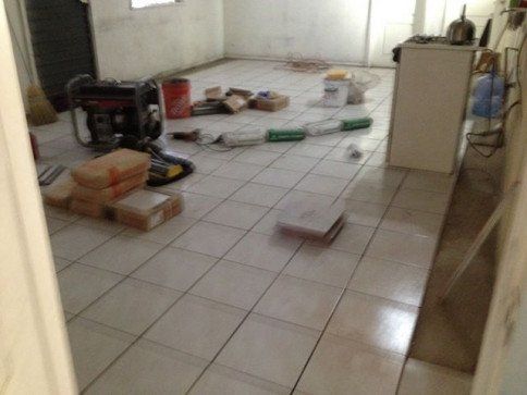 A room with tile floors and boxes on the floor.