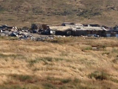 A group of buildings are sitting in the middle of a field.