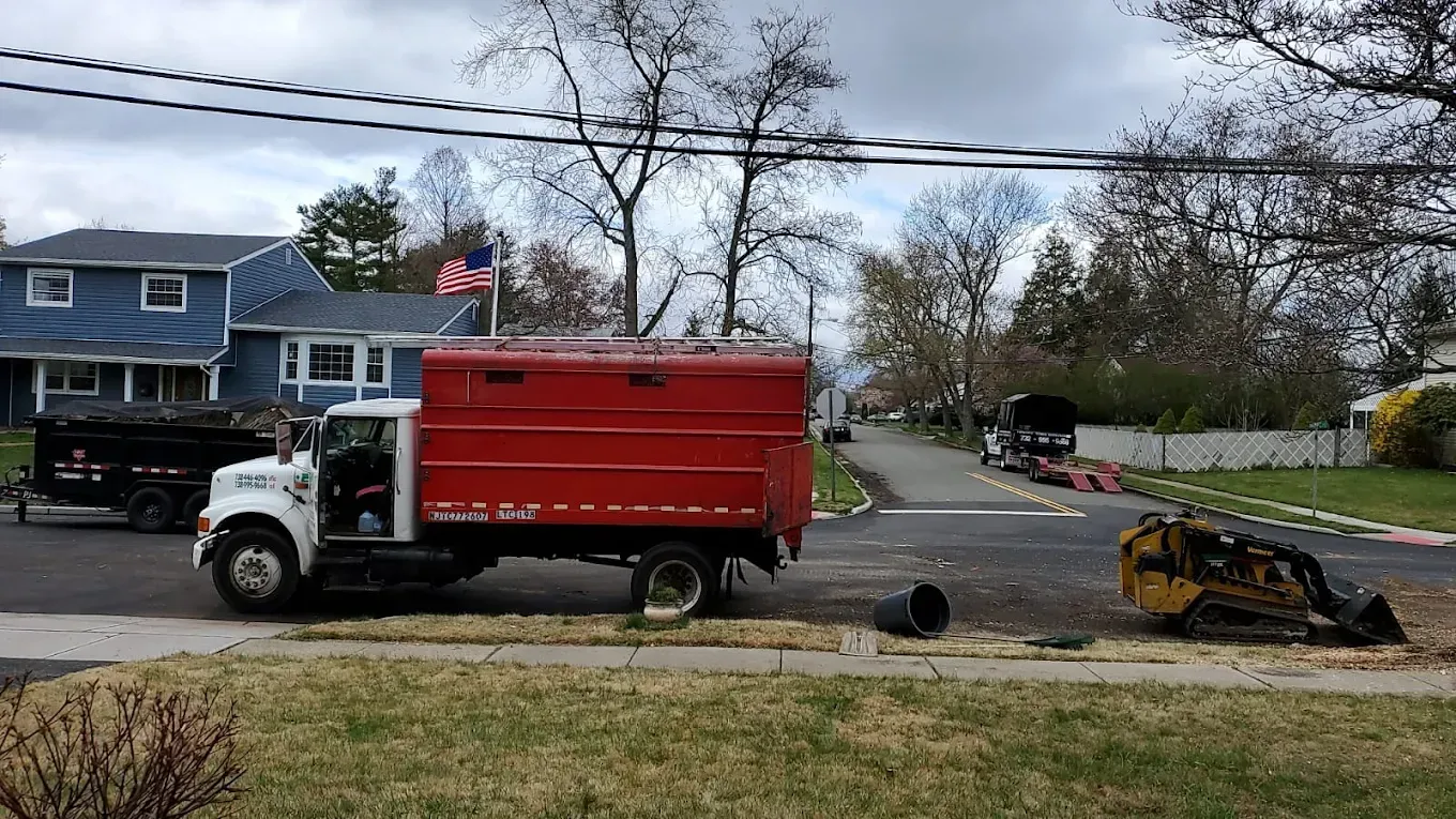 Red truck parked on a residential street; a machine is in the distance.