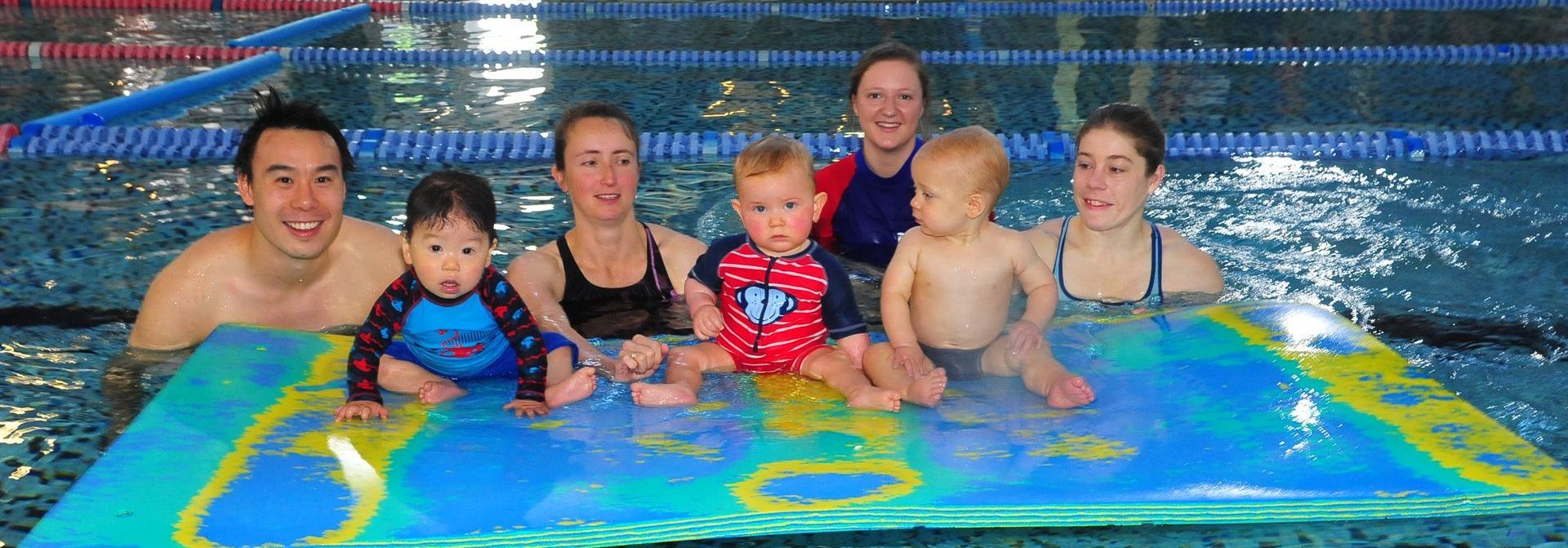 A group of people are posing for a picture in a swimming pool.