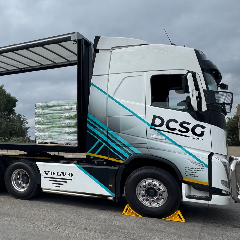 A large semi truck is parked in front of a building.
