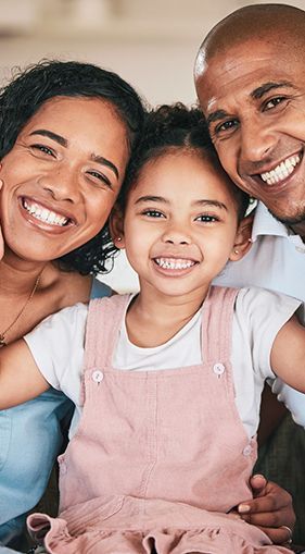 A family is posing for a picture together and smiling.