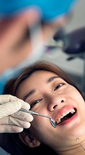 A woman is having her teeth examined by a dentist.