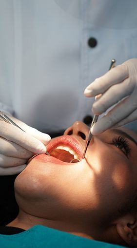 A woman is getting her teeth examined by a dentist.