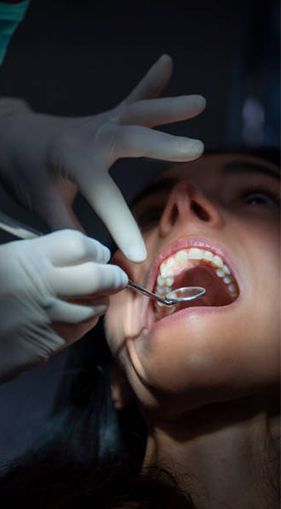 A woman is getting her teeth examined by a professional dentist.