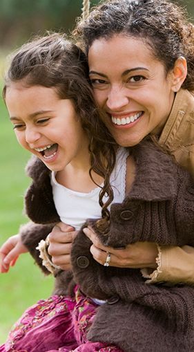 A woman is carrying a little girl on her back.