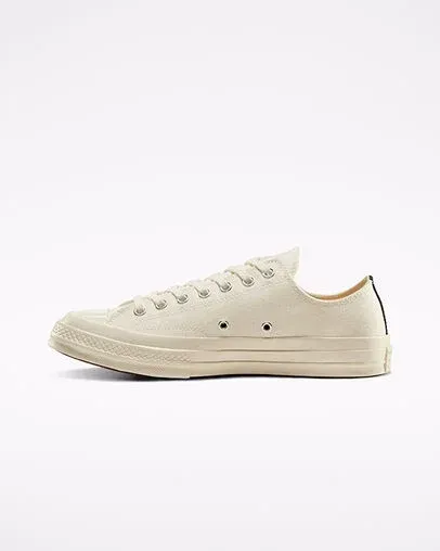 Cream Converse shoe with red heart and eyes on the side.