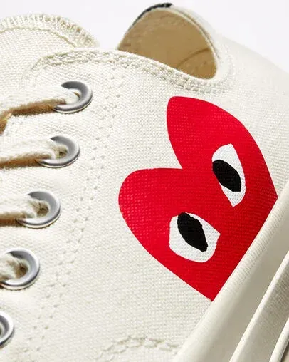 Off-white canvas shoe with a large red heart graphic featuring black eyes.