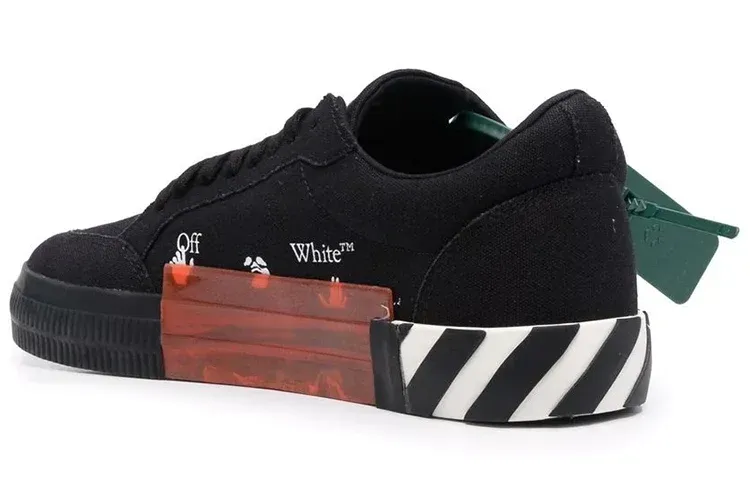 Black Off-White sneaker with red translucent block and diagonal striped sole. Green tag.