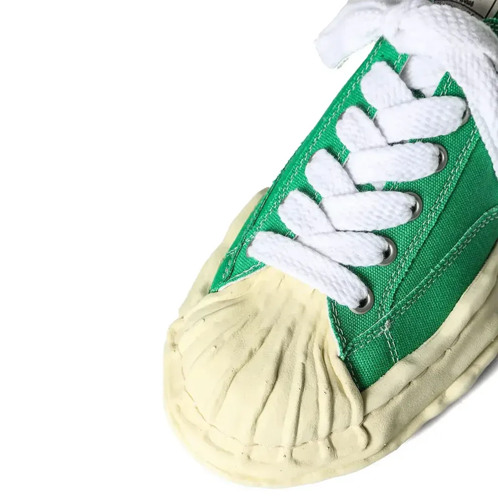 Green and white canvas sneaker, cream rubber toe cap and white laces.