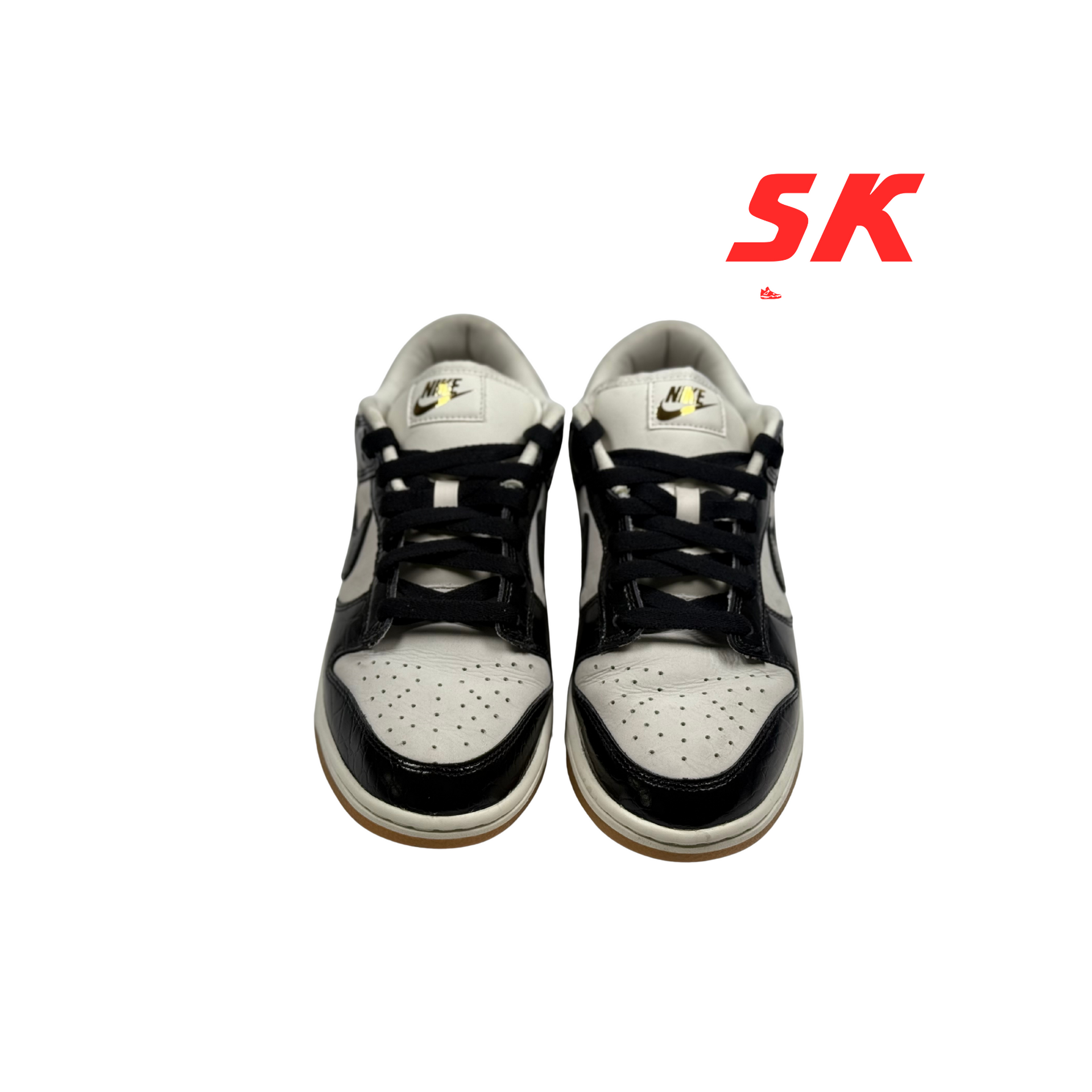 A pair of black and white Nike Dunk Low sneakers with black laces, viewed from the front.