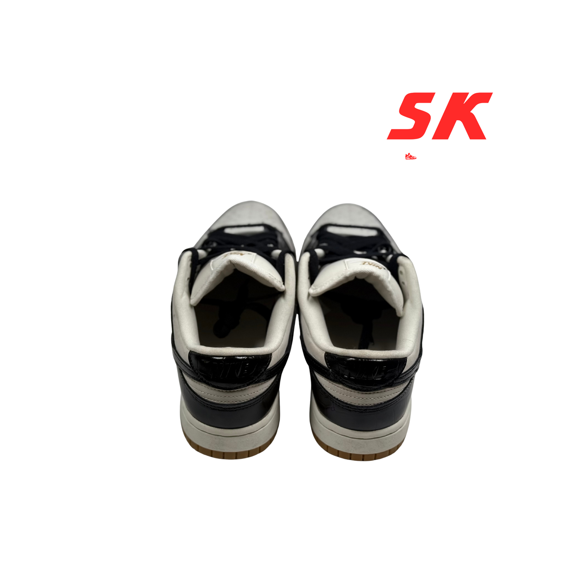 Pair of black and white Nike Dunk sneakers with tan soles.