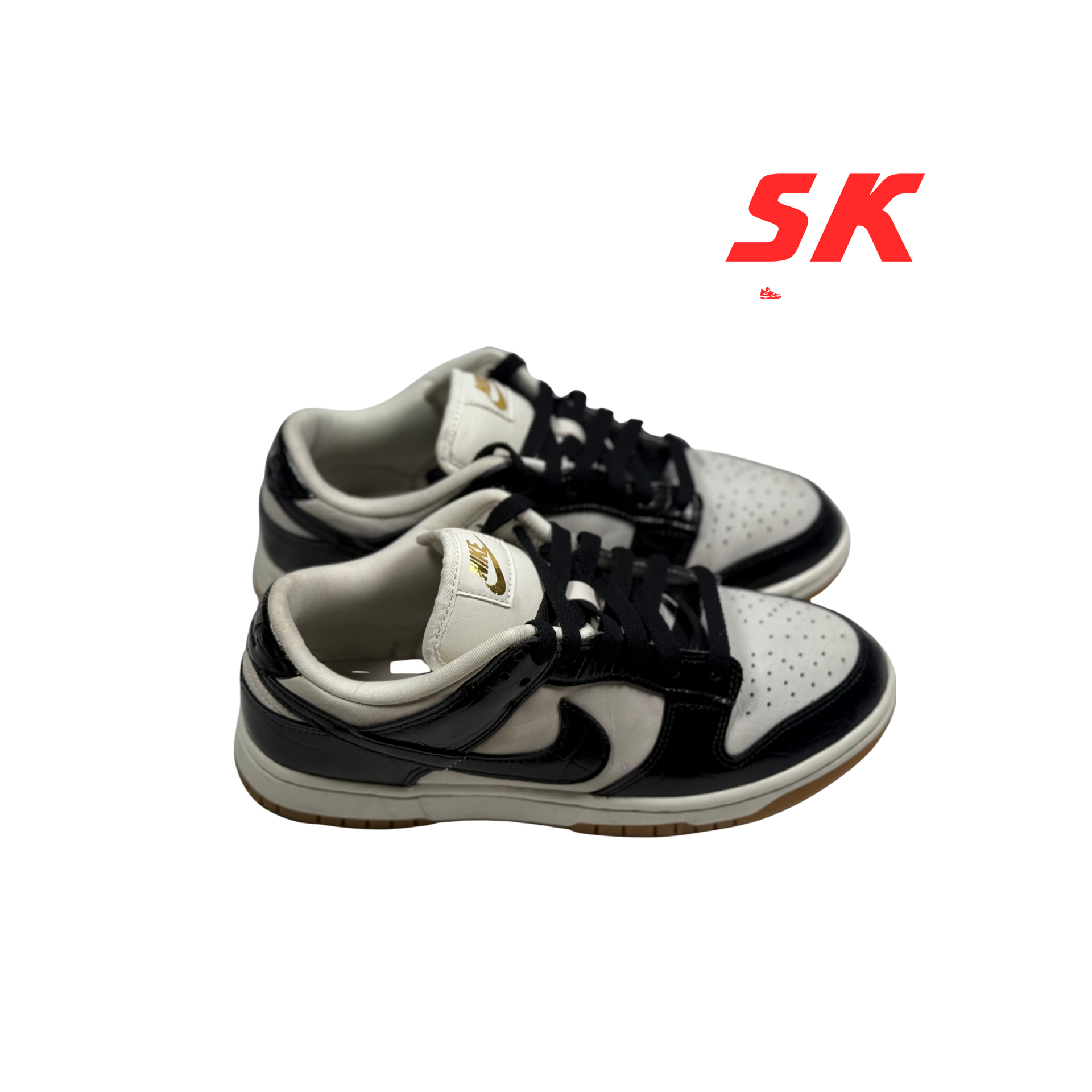 Pair of black and white Nike Dunk sneakers with tan soles.