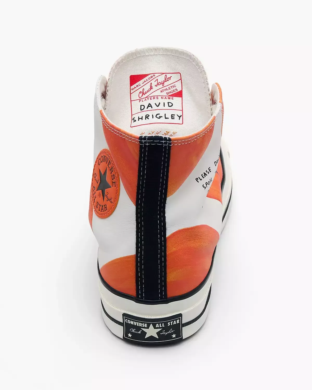 White and orange Converse high-top sneaker, back view. Black stripe down the heel, orange circle on the side.
