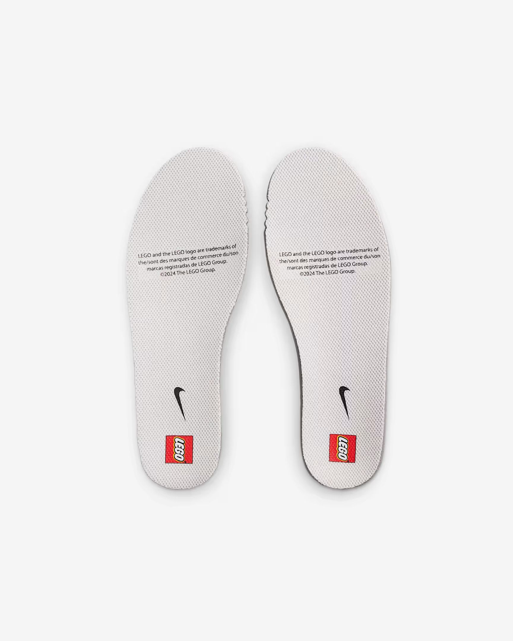 Two white Nike shoe insoles with black text, a red square, and a small black Nike logo.